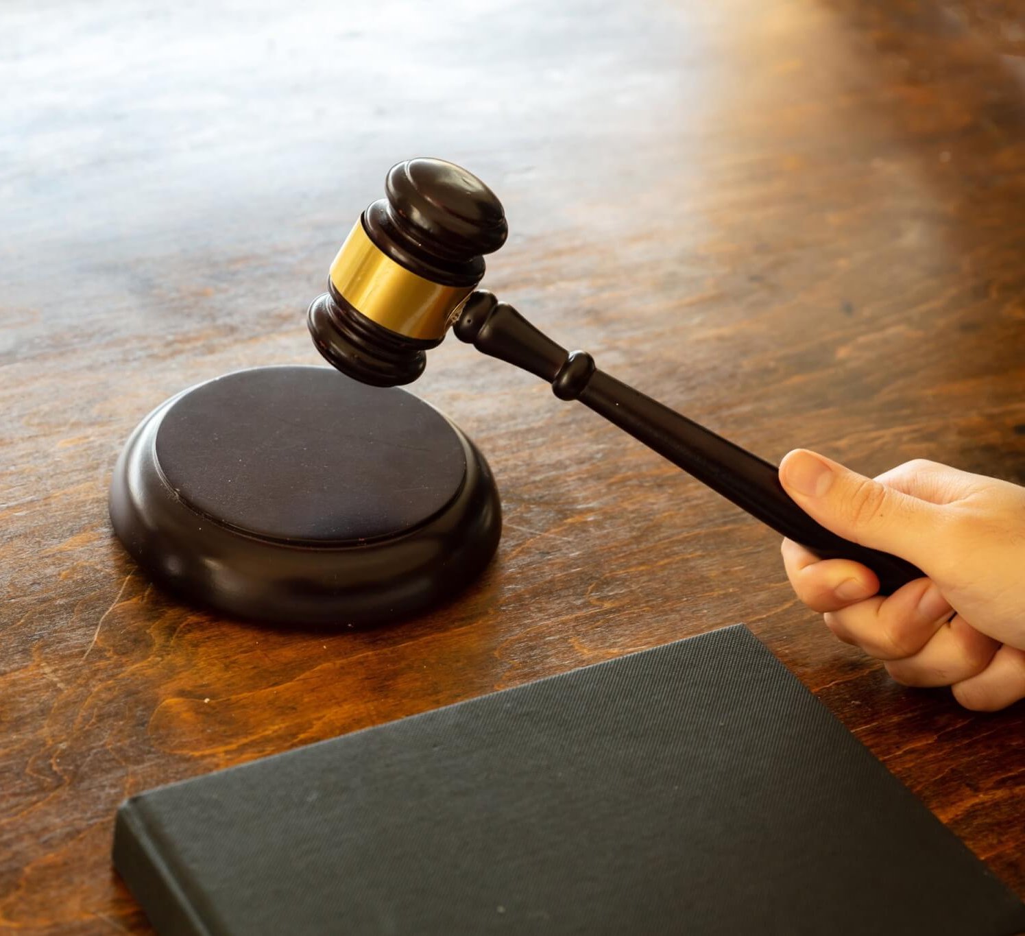 Judge hitting a gavel on wooden desk background. .